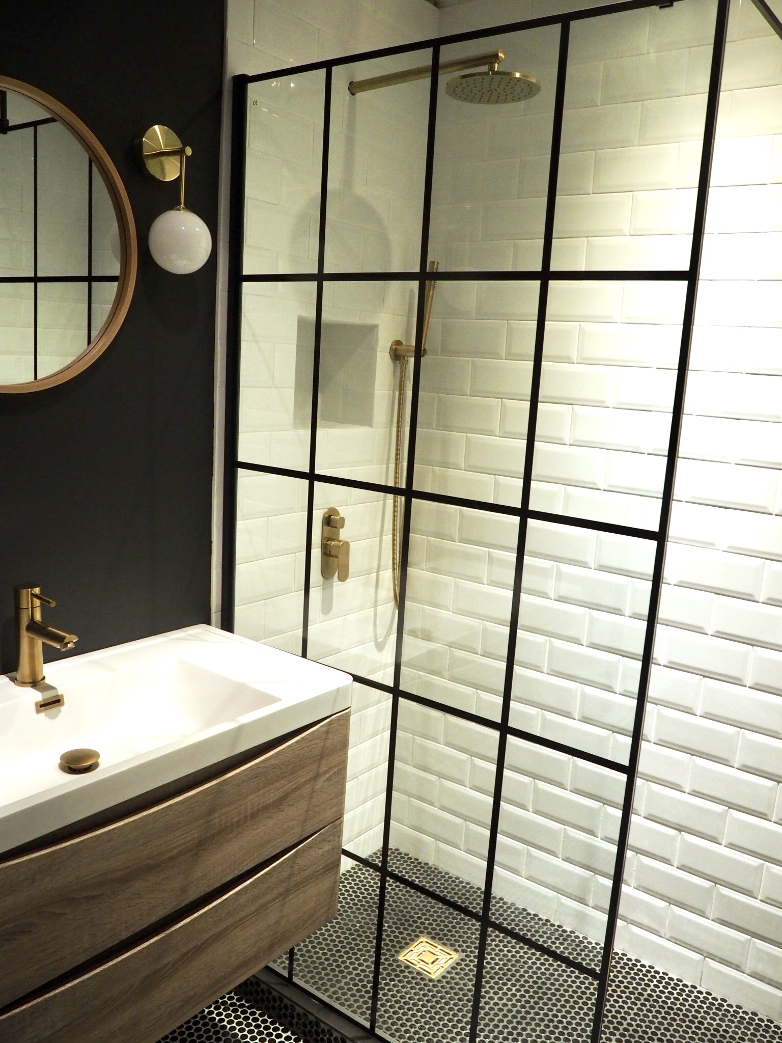  Black walled bathroom with gold fixtures and natural wood vanity unit