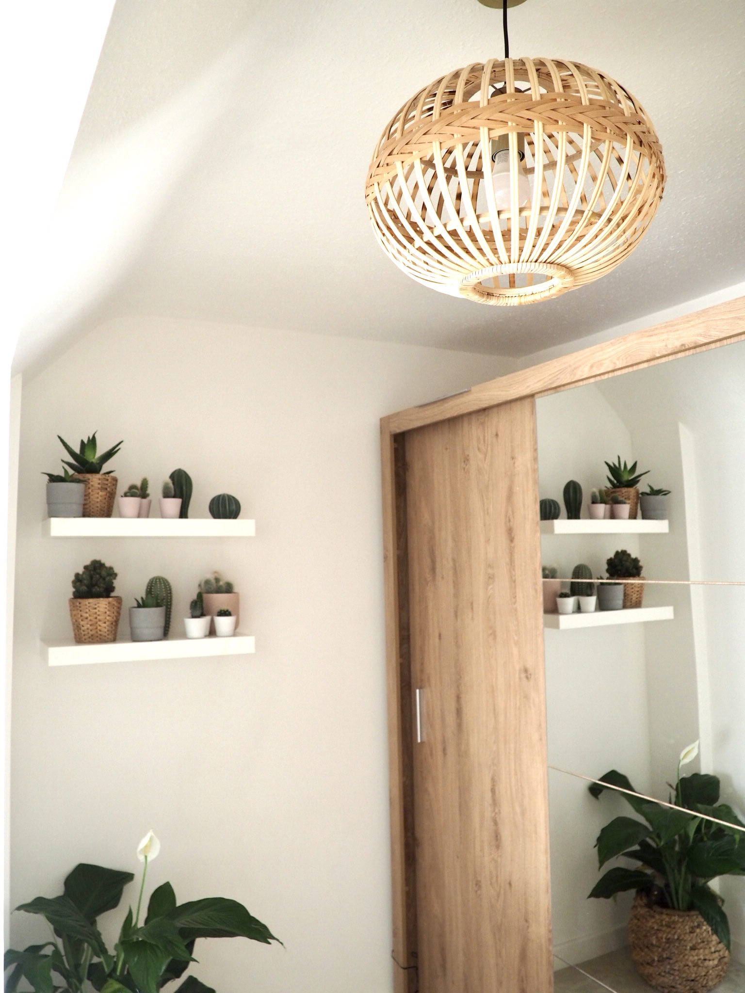 Bamboo pendant light by Wayfair hanging near the Instrument London wood wardrobes and the shelves with cactuses on.